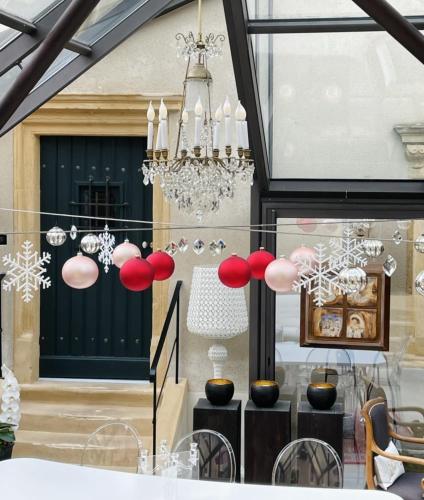 a store front with a chandelier in the window at La Maison Ruffinoise in Sainte-Ruffine