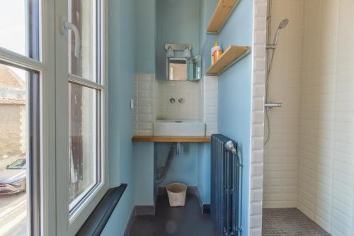a bathroom with a sink and a toilet and a window at Le Cordelier - Jardin en plein centre - Quais de Seine in Troyes