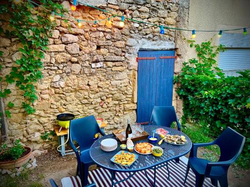 - une table avec des assiettes de nourriture sur une terrasse dans l'établissement Maison de village avec jardin à 3 km des plages., à Loupian