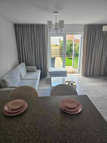 una sala de estar con una mesa con dos platos marrones. en Entire 2 Bedroom House Modern Stylish Luxury, en Plymouth