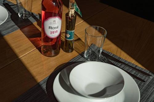 a table with a white plate and a bottle of wine at Zirbenchalet Klippitz - Erholung mit Zirbenkraft in Bad Sankt Leonhard im Lavanttal