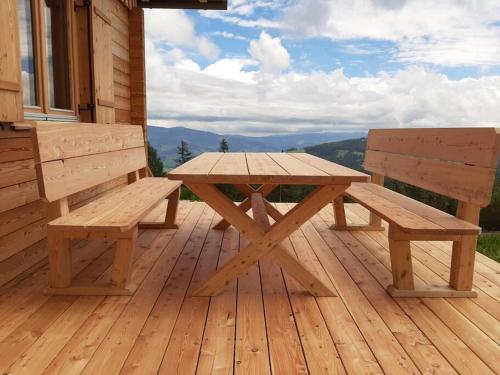 a wooden picnic table and bench on a deck at Zirbenchalet Klippitz - Erholung mit Zirbenkraft in Bad Sankt Leonhard im Lavanttal