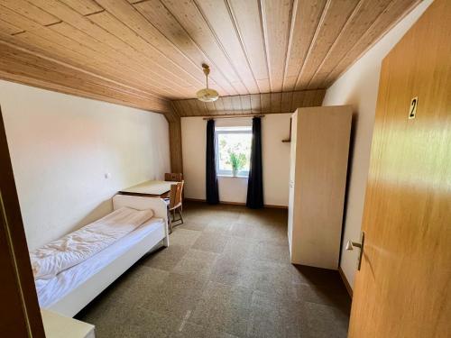 a room with a bed and a desk and a window at Hotel Bollerott in Selm