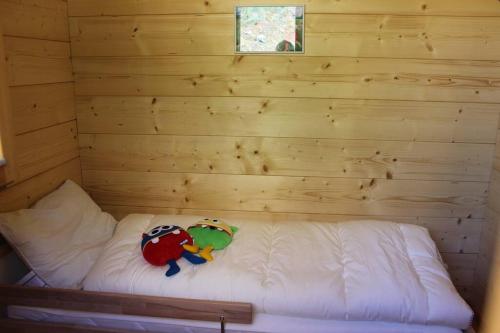 a log cabin with two stuffed animals on a bed at Zirbenchalet Klippitz - Erholung mit Zirbenkraft in Bad Sankt Leonhard im Lavanttal