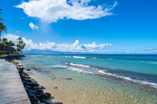 a beach with rocks and the ocean on a sunny day at Maui Sands Seaside 713 · MSS 713 Charming 1BD Near Beach in Kahana