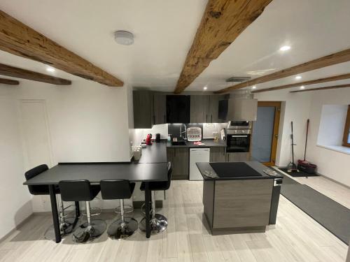 une cuisine avec une table noire et des chaises dans l'établissement Appartement proche de la Suisse, à Heiwiller