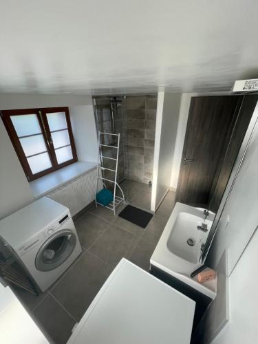 y baño con lavadora y lavamanos. en Appartement proche de la Suisse, 