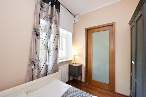 グダニスクにあるYOURAPART Gdańsk Starówkaのベッドルーム1室(ベッド1台、窓、鏡付)