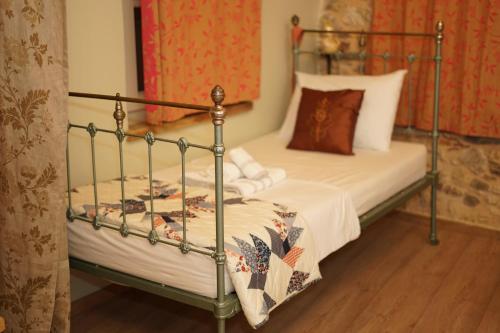 a bedroom with a bed with a metal frame at Irene's Mansion in Vrontados