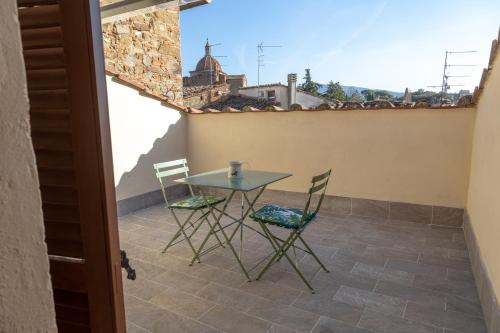 une table et des chaises sur le balcon d'une maison dans l'établissement La Terrazza di Emy - affitto turistico, à Arezzo