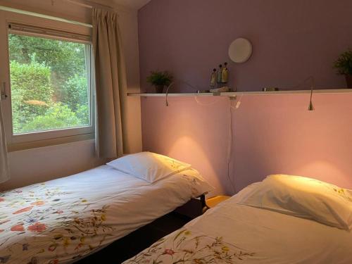 Tempat tidur dalam kamar di Ruime en comfortabele bungalow aan bosrand