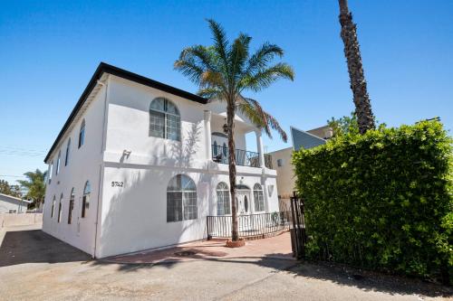 a white house with palm trees in front of it at 3bed 2bath apartment near universal studio hollywood sleep 7 in Los Angeles