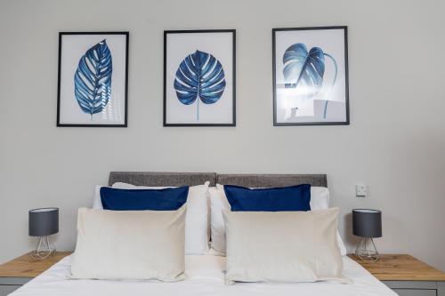 a bedroom with four pictures on the wall above a bed at Spacious, High Spec & Modern House by Ark SA in Sheffield