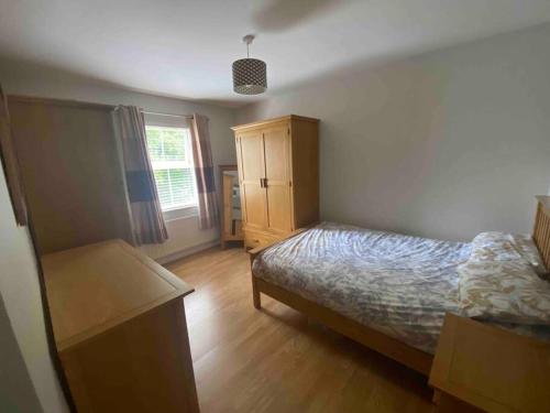 a bedroom with a bed and a dresser at Loughview Gardens - family friendly in Omagh