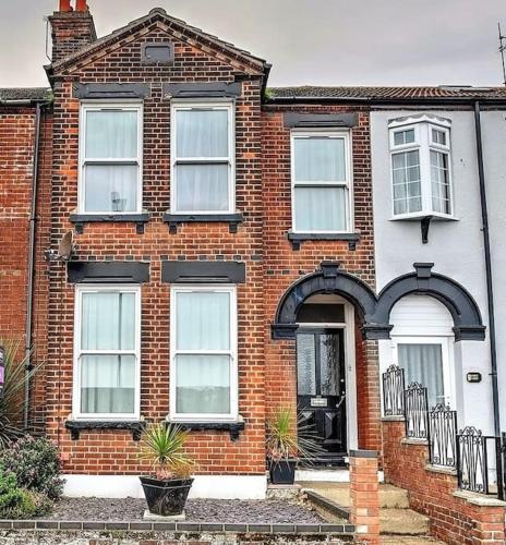 a brick house with a black and white at Gorgeous Gorleston holiday home in Gorleston-on-Sea