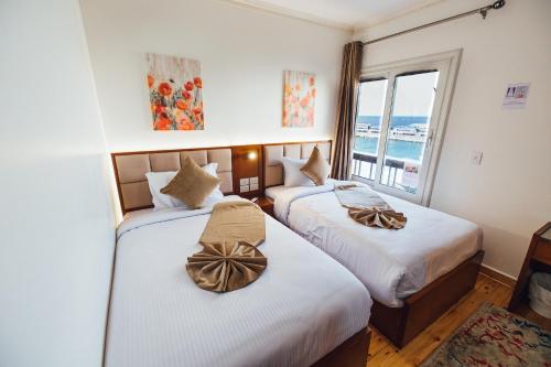 - 2 lits dans une chambre d'hôtel avec fenêtre dans l'établissement Gleem Luxury Apartments, à Alexandrie