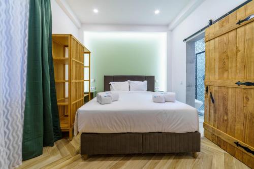 a bedroom with a large white bed and green curtains at Atlantic Bliss in Albufeira