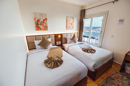 two beds in a room with a view of the ocean at Gleem Luxury Apartments in Alexandria