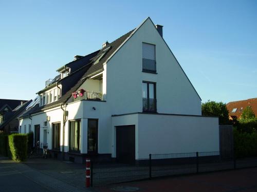 Ein weißes Haus an der Seite einer Straße in der Unterkunft Dachwohnung Nähe Clemenshospital in Münster