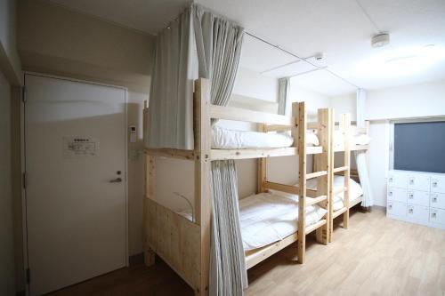 名古屋市にあるグローカル名古屋バックパッカーズホステルの窓付きの客室で、二段ベッド2台が備わります。