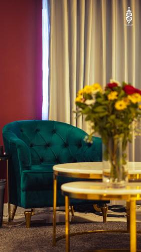 a green couch and a table with a vase of flowers at Saladin Boutique Hotel in Jerusalem