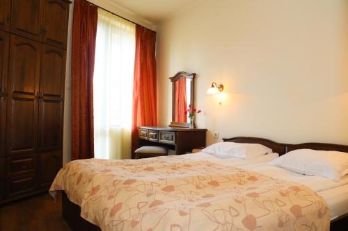 a hotel room with two beds and a window at Apartments & Studios Mountain Romance in Bansko