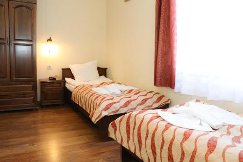 two beds sitting next to each other in a room at Apartments & Studios Mountain Romance in Bansko