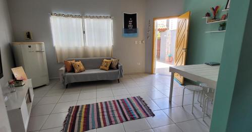 a living room with a couch and a kitchen at Casa Bopiranga II in Itanhaém