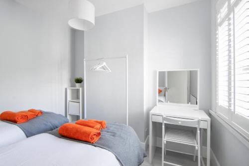 a white room with two beds and a desk and a mirror at Cloud9 Accommodation in Croydon