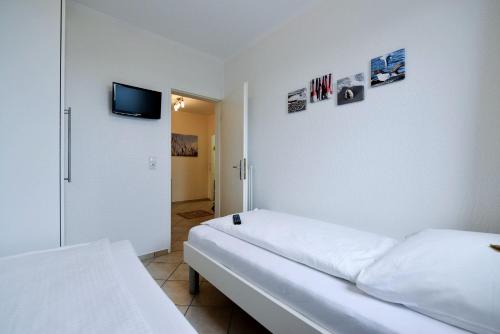 um quarto com duas camas e uma televisão na parede em Strandhochhaus SA12 em Cuxhaven