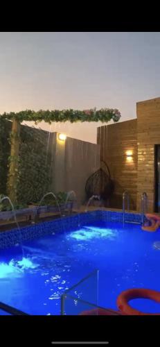 a large swimming pool with blue water in a room at اكواخ الغصن الريفيه in Jeddah