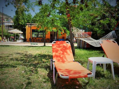 an orange chair and a hammock in a park at Nefeli in Vasiliki