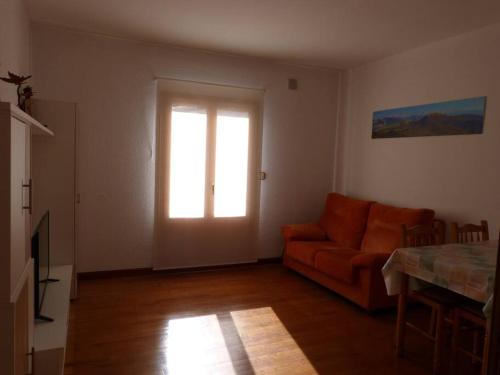 a living room with an orange couch and a window at Eguzkilore - Apartamento luminoso y soleado in Elizondo