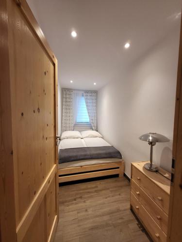 a small bedroom with a bed and a window at Apartament U Janicka in Zakopane