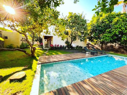 una piscina en un patio con terraza de madera en Pousada Noah Noah, en São Miguel dos Milagres