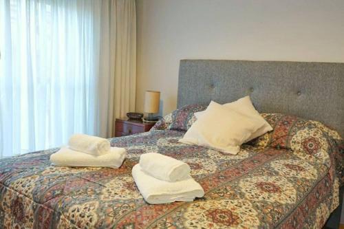 a bedroom with a bed with towels on it at Clásico y moderno departamento - olivos in Olivos