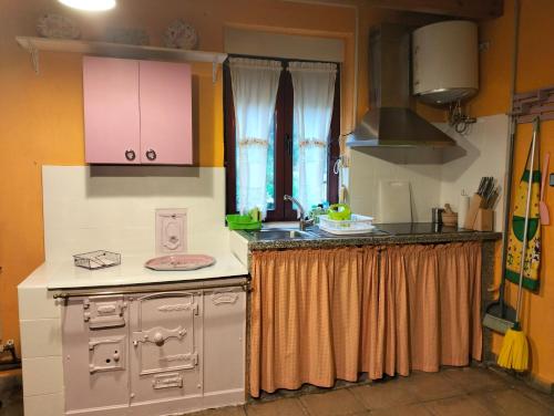 a kitchen with a sink and a stove top oven at Casa Manuel y Ana María. in Llombera
