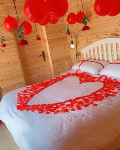 a bed with a heart made out of red roses at كوخ الغصن الريفي in Jeddah