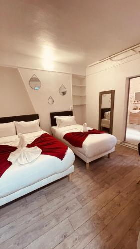 a bedroom with two beds and a mirror at HOTEL LOUVAIN in Paris