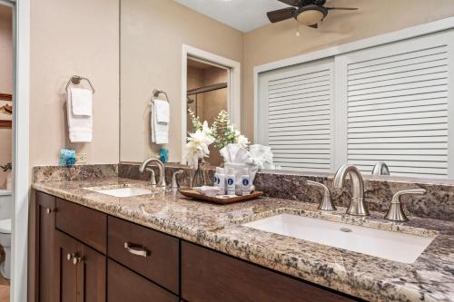 a bathroom with two sinks and a large mirror at Kaanapali Plantation 53 in Lahaina