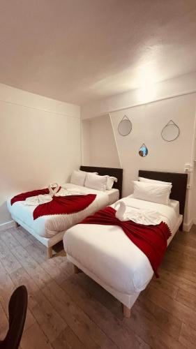 two beds in a hotel room with at HOTEL LOUVAIN in Paris