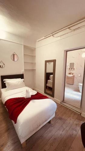 a bedroom with a large bed and a mirror at HOTEL LOUVAIN in Paris