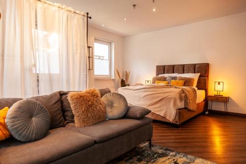 a living room with a couch and a bed at nidusROOMS: Suite Hockenheim in Hockenheim