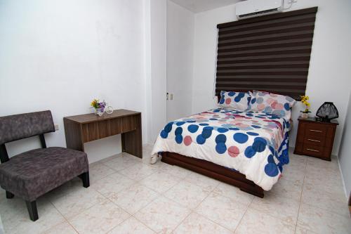 a bedroom with a bed and a chair at Habitaciones privadas, Casa de Amber, Manta in Manta