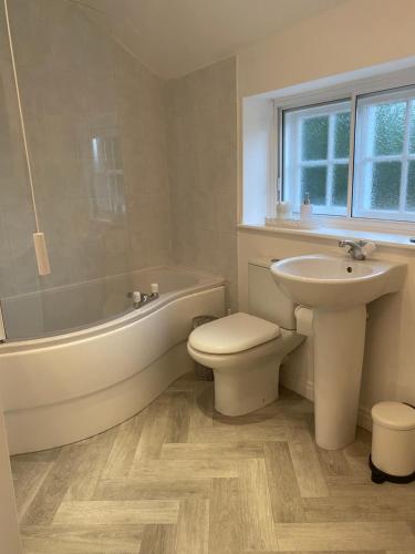 een badkamer met een bad, een wastafel, een toilet en een bad. bij Jasmine Cottage in Gilling
