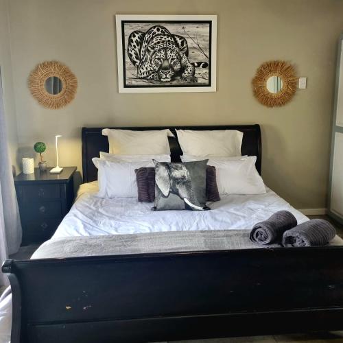 a bed with white sheets and pillows in a bedroom at Angel 8 AirBnB Apartment 1 in Robertson
