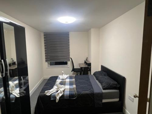 Lovely room in Chelsea في لندن: غرفة نوم صغيرة مع سرير وطاولة