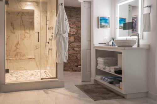 a bathroom with a shower with a glass door at NAPA Suite • Hot Tub • Downtown • Original Art in Eureka Springs