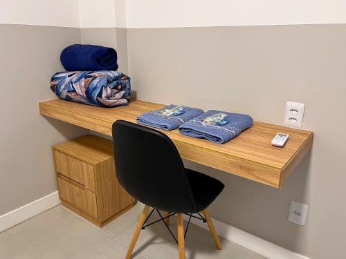 a desk with a chair and blue towels on it at Apto Reformado e Decorado no Centro in Florianópolis