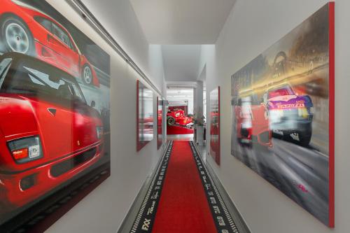 a hallway with pictures of cars on the walls at Hotel Maranello Village in Maranello